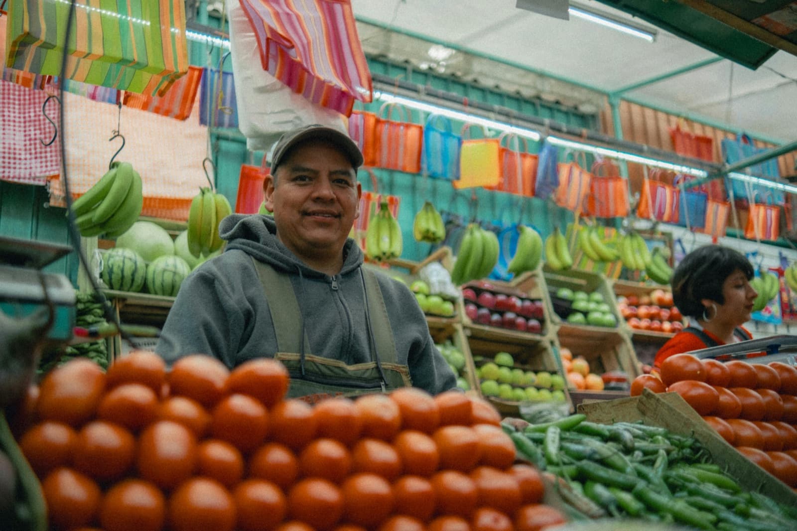 Comerciante atendiendo su puesto de frutas y verduras