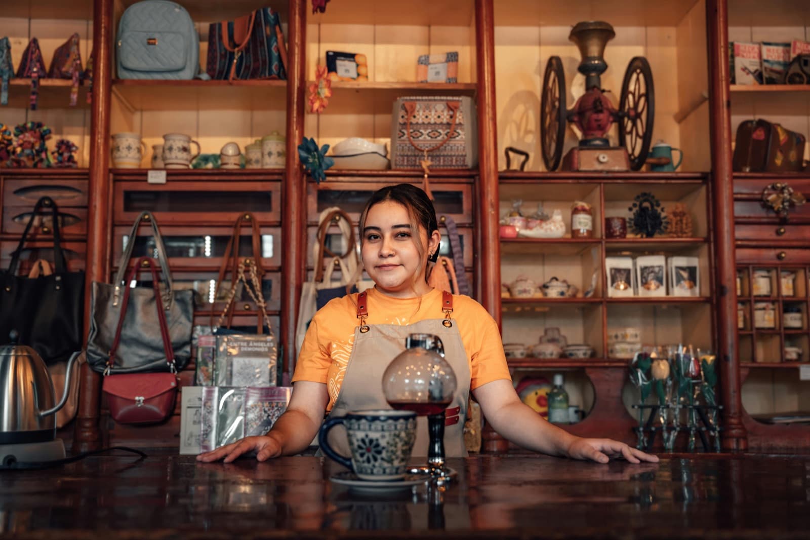 Emprendedora en su negocio con inventario y productos artesanales